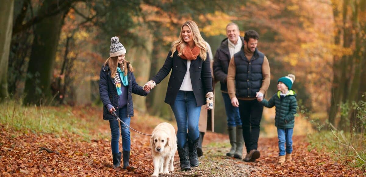 Family of three generations walking a dog