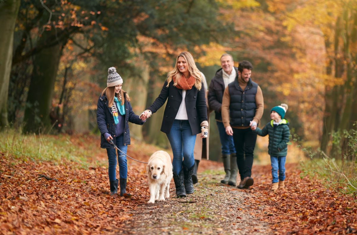 Family of three generations walking a dog